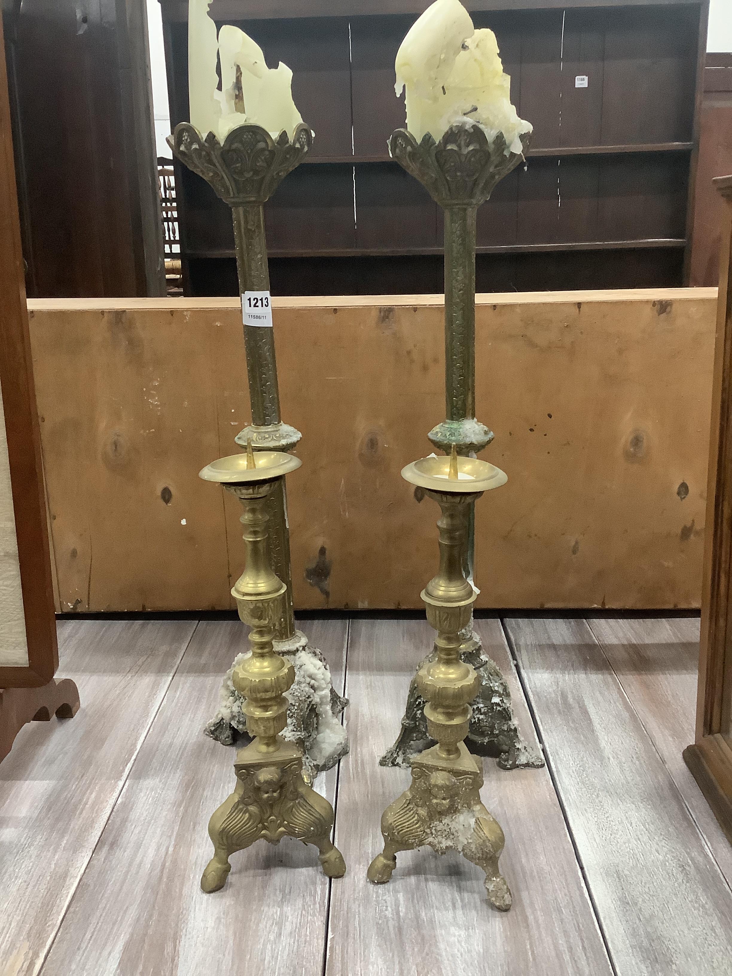 A pair of late 19th century brass altar sticks, height 70cm and a smaller pair of pricket candlesticks, height 42cm